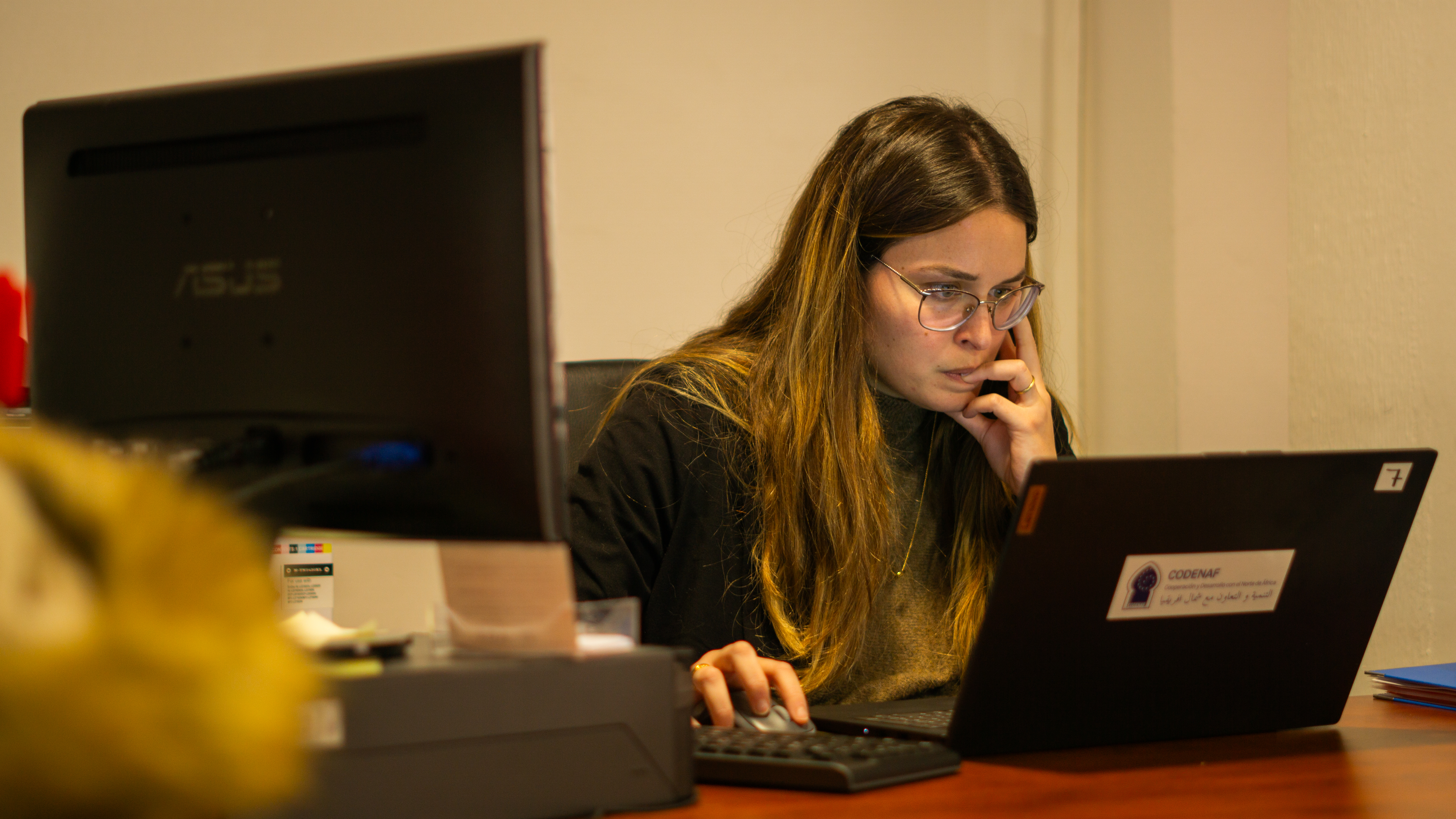 Mujer de gafas trabajando con un portátil 